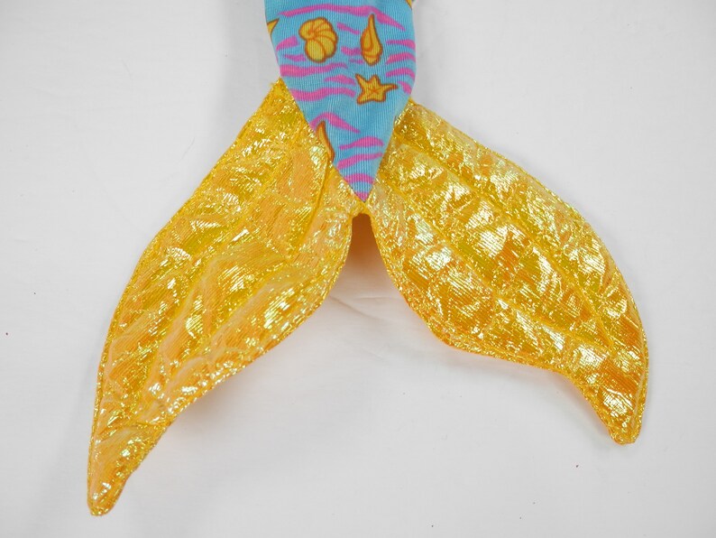 May include: A mermaid tail costume with a blue and pink fabric top and a yellow iridescent fabric bottom.