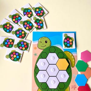 Peut inclure: Un puzzle de tortue en bois coloré avec un corps vert et un visage qui cligne de l'œil. Le puzzle comprend des pièces hexagonales de différentes couleurs et des cartes de tortues assorties. Jouet éducatif pour enfants.