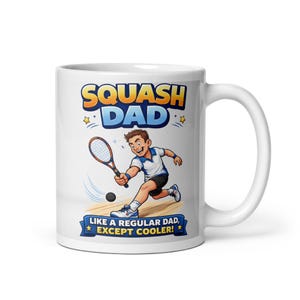 Könnte beinhalten: Weißer Keramikbecher mit einer Illustration eines Squashspielers. Der Becher zeigt den Text "SQUASH DAD" in Orange und Blau sowie den Satz "LIKE A REGULAR DAD, EXCEPT COOLER!" darunter.