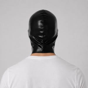 May include: A black, glossy, form-fitting hood that covers the entire head and neck. The material has a smooth, reflective surface with a visible vertical seam running down the center back. The hood is worn over a plain, solid white t-shirt.