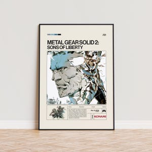 May include: Framed poster featuring the text "METAL GEAR SOLID 2: SONS OF LIBERTY" with a stylized illustration of a character in shades of blue, white, and black. The poster includes the Konami logo and a small image of characters.