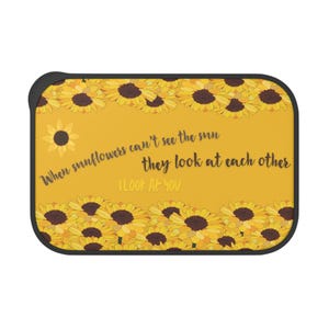 May include: A rectangular phone case with a yellow background and a black border. The case features a sunflower design at the top and bottom, with the text "When sunflowers can't see the sun they look at each other I Look At You."
