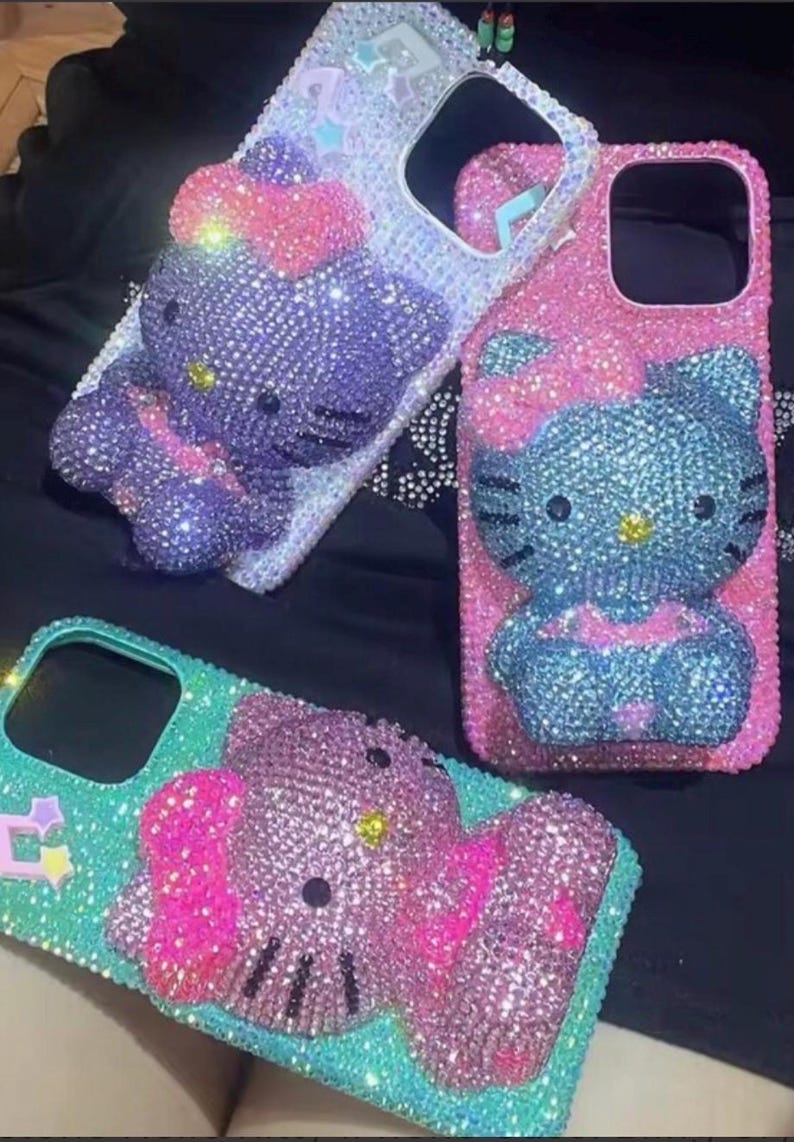 Puede incluir: Tres fundas de tel&eacute;fono adornadas con pedrer&iacute;a con un dise&ntilde;o de Hello Kitty. Las fundas son en tonos rosa, azul, morado y turquesa, con brillantes pedrer&iacute;a. Las fundas tienen recortes para la c&aacute;mara y los botones.