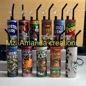 May include: A collection of cylindrical water pipes with various designs and text, including "Frosted Buds," "Toner Dat," and "Kushy Pebbles." Each pipe features a black mouthpiece and a glass bowl.