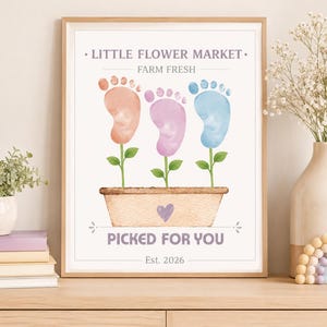 Puede incluir: Una lámina enmarcada con el texto LITTLE FLOWER MARKET FARM FRESH y PICKED FOR YOU con Est. 2026. El diseño muestra tres huellas de pies en acuarela de color naranja, morado y azul, cada una unida a un tallo verde en una maceta color canela.