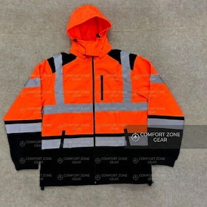 May include: High-visibility orange work jacket with a hood, black accents, and reflective silver stripes. The jacket features a full-length zipper and multiple pockets. The text "COMFORT ZONE GEAR" is printed on the jacket.