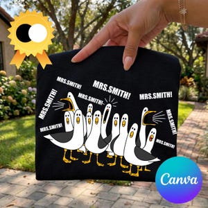 Pode incluir: Bolsa tote preta com uma ilustração de desenho animado de gaivotas gritando "MRS.SMITH!". As gaivotas são brancas com asas pretas e pés amarelos. O logotipo da Canva é visível no canto inferior direito.