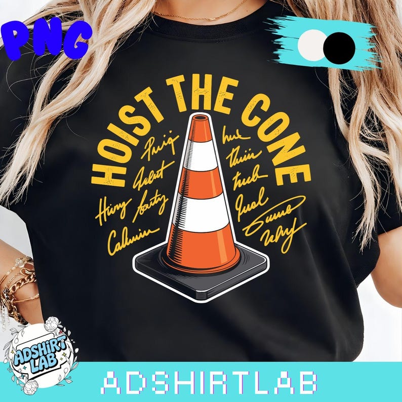 May include: Black t-shirt with the text "HOIST THE CONE" in yellow, surrounding an orange and white traffic cone graphic. The shirt also features several names in a handwritten style. The brand name "ADSHIRTLAB" is at the bottom.