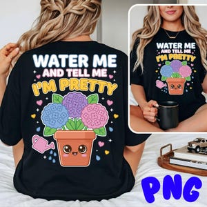 Puede incluir: Camiseta negra con el texto "WATER ME AND TELL ME I'M PRETTY" sobre una ilustración de dibujos animados de una planta en maceta con flores azules, moradas y rosas. Incluye una regadera rosa.