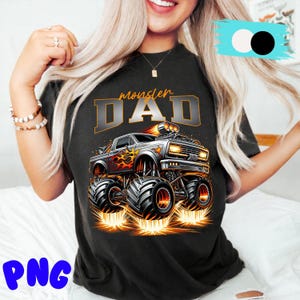 Pode incluir: T-shirt preto com um design de monster truck e o texto "monster DAD". O caminh&atilde;o tem chamas e pneus grandes. O design usa tons de cinza, laranja e amarelo.