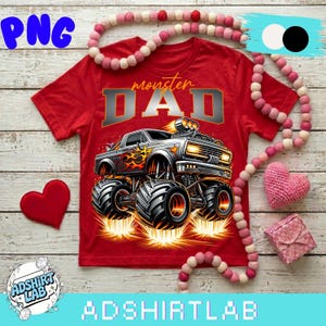 Pode incluir: Camiseta vermelha com um gr&aacute;fico de um monster truck e o texto "monster DAD" em prata e laranja. O monster truck tem chamas e pneus grandes. A camiseta &eacute; cercada por elementos decorativos, incluindo um cora&ccedil;&atilde;o e uma guirlanda de contas.