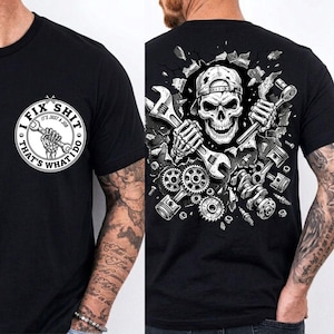 May include: Black t-shirt with a mechanic-themed design. The front features a circular graphic with the text "I FIX SHIT, THAT'S WHAT I DO." The back displays a skull wearing a cap, holding wrenches, surrounded by engine parts.