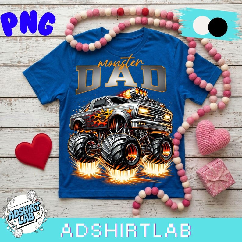Pode incluir: Uma camiseta azul com um design de monster truck e o texto "monster DAD". O monster truck &eacute; prateado com chamas laranja e pneus pretos grandes. A imagem tamb&eacute;m inclui um cora&ccedil;&atilde;o vermelho e uma caixa de presente rosa.