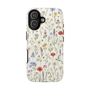 Könnte beinhalten: Eine Handyhülle mit cremefarbenem Hintergrund, bedeckt mit einem Muster aus bunten Wildblumen und kleinen Insekten. Zu den Blumen gehören rote Mohnblumen, Gänseblümchen und Lavendel. Die Hülle hat einen schwarzen Kameraausschnitt.