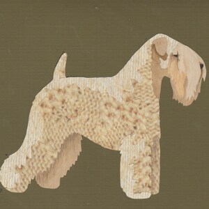 May include: A beige soft-coated wheaten terrier dog stands on a brown background. The dog is made of paper and has a textured appearance.