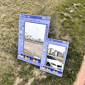 Puede incluir: Dos obras de arte de tem&aacute;tica azul que se asemejan a la interfaz del programa Windows Paint cl&aacute;sico. La m&aacute;s grande muestra un paisaje urbano, la m&aacute;s peque&ntilde;a un coche blanco. Ambas est&aacute;n sobre hierba.