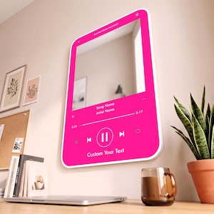 May include: A rectangular wall mirror with a bright pink frame designed to resemble a digital music player interface. The interface includes white text reading PLAYIN FROM PLAYLIST, Song Name, Artist Name, 0:24, 5:17, and Custom Your Text.