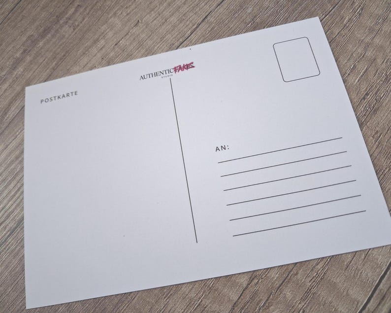 May include: A white postcard with the text "POSTKARTE" and "AUTHENTIC PARIS" in the upper left corner. The postcard has a rectangular area for a stamp and lines for the recipient's address.