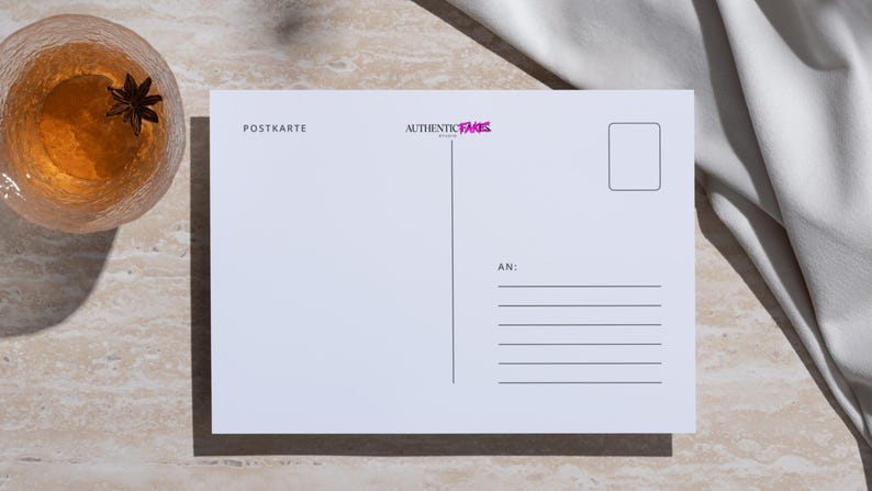 May include: A white postcard with the text "POSTKARTE" and "AUTHENTIC FAKES" in pink. A glass of amber liquid with a star anise sits to the left. A white cloth is draped on the right.