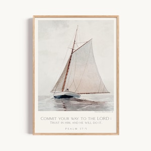 Op de afbeelding: Een ingelijste kunstdruk met een aquarel van een zeilboot op het water. De tekst onderaan luidt: COMMIT YOUR WAY TO THE LORD: TRUST IN HIM, AND HE WILL DO IT. PSALM 37:5. De lijst is gemaakt van lichtgekleurd hout.