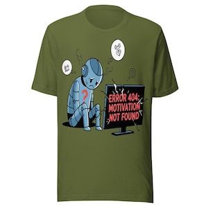 Könnte beinhalten: Ein olivgrünes T-Shirt mit einer Grafik eines traurigen blauen Roboters, der vor einem gesprungenen Computermonitor sitzt. Auf dem Bildschirm steht der rote Text ERROR 404: MOTIVATION NOT FOUND. Der Roboter hat ein rotes Fragezeichen auf der Brust.