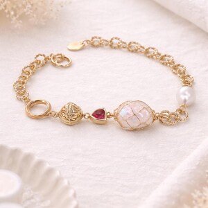 Pulsera de oro hecha a mano con dije de ópalo, perla y rubí, cadena ajustable, joyería elegante.