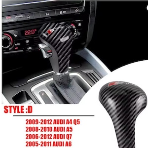May include: Carbon fiber style gear shift knob with the S line logo. The knob is black with a textured pattern and a silver base. The image also shows the car's dashboard and climate control system.