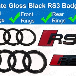 May include: Ultimate Gloss Black RS3 Badge Set. The set includes a grill badge, front rings, rear rings, and rear badge. The badges feature a black finish with red accents. The text "RS3" is visible on the badges.
