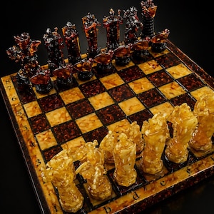 May include: A detailed chess set with amber-colored pieces and a checkered board. The pieces are intricately designed, with dark brown and amber hues. The board has a brown and tan pattern, creating a luxurious look.