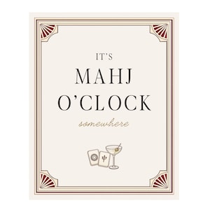 May include: Cream-colored rectangular sign with a decorative border and the text "IT'S MAHJ O'CLOCK somewhere." Below the text are illustrations of two Mahjong tiles and a martini. The sign has a vintage aesthetic.