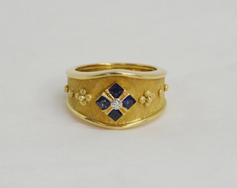 18 Karat yellow gold handmade tapered band, set with Sapphires and Diamond.