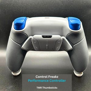 May include: A grey and black Control Freakz Performance Controller with blue detailing. Features include TMR thumbsticks, mouse click triggers, full face clicky, and back paddles. The controller has a textured grip for improved gaming.