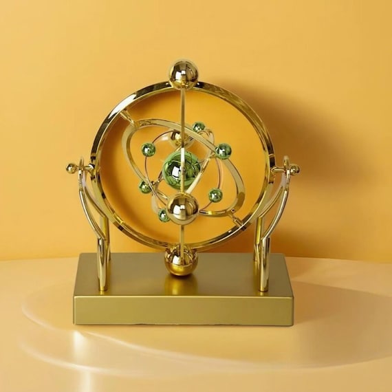 A celestial-orbit pendulum sculpture that mimics planetary motion on your desk — part Newton's cradle, part orrery, and fully hypnotic.
