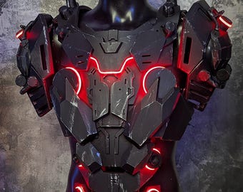 May include: Black and gray futuristic chest armor with red LED accents. The armor is displayed on a black mannequin and features intricate geometric designs and glowing red lights. The text "TWOHORNSUNITED CREATIONS" is visible at the bottom.