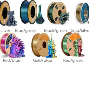 May include: A selection of 3D printer filament spools in a range of colours: black/gold, grey/silver, blue/green, black/green, gold/silver, black/rose red, gold/red copper, red/blue, gold/blue, red/green, purple, and green. Each spool is displayed with a 3D printed model.