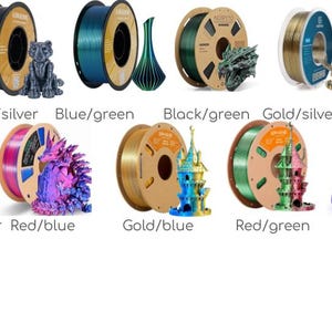 K&ouml;nnte beinhalten: Eine Sammlung von 3D-Drucker-Filamentrollen in verschiedenen Farben, darunter Schwarz/Gold, Grau/Silber, Blau/Gr&uuml;n, Schwarz/Gr&uuml;n, Gold/Silber, Schwarz/Rosarot, Gold/Rotkupfer, Rot/Blau, Gold/Blau, Rot/Gr&uuml;n, Lila und Gr&uuml;n. Jede Rolle wird mit einem 3D-gedruckten Modell pr&auml;sentiert.