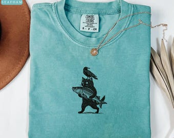 Linocut Cat Carrying Fish Shirt, Whimsical Raven Cat Art, Quirky Black Cat Gift, Comfort Colors Cat T-Shirt, Cozy Sweatshirt, Hoodie
