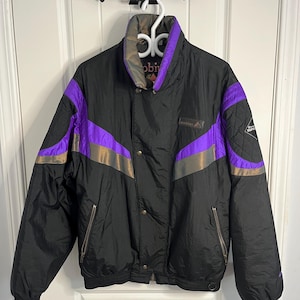 May include: Black vintage jacket with purple and gold accents. The jacket features a high collar, snap closures, and zippered pockets. The brand name "mobins" is visible on the chest. A retro style windbreaker.