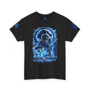 May include: A black short-sleeved t-shirt featuring a graphic of the Mortal Kombat character Sub-Zero surrounded by blue ice effects. The design includes the text Mortal Kombat, Japanese characters, and a dragon logo on the sleeves and chest.