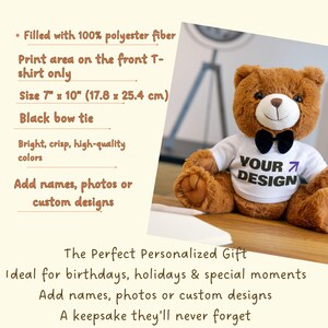 Op de afbeelding: Een bruine teddybeer met een wit t-shirt met de tekst "YOUR DESIGN" en een zwarte vlinderdas. De beer is ongeveer 17,8 cm bij 25,4 cm en gevuld met polyestervezel. Het t-shirt is ontworpen voor aangepaste ontwerpen.
