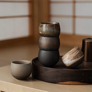 May include: A set of three white ceramic vases of different heights. The vases have a textured, ridged design. The tallest vase is about 25 cm tall, the medium vase is 20 cm, and the smallest is 15 cm.