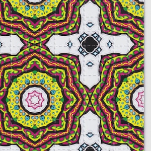 May include: A colourful, patterned design with a repeating motif of a white cross shape and circular patterns. The design incorporates yellow, pink, green, and black elements, creating a psychedelic aesthetic.