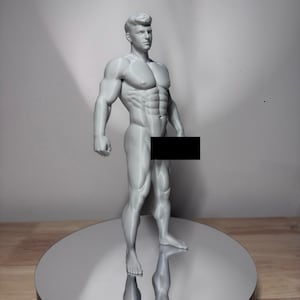 Op de afbeelding: Een lichtgrijs, driedimensionaal geprint beeldje van een gespierd, atletisch menselijk figuur in een neutrale houding. Het figuur heeft gedefinieerde buik- en borstspieren, met een zwarte rechthoekige balk die het bekkengebied bedekt.