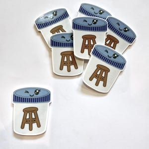 May include: A collection of die-cut stickers featuring a white laboratory specimen container with a blue striped lid and a brown stool illustration. Each container has a winking kawaii face printed on the lid, creating a playful design.