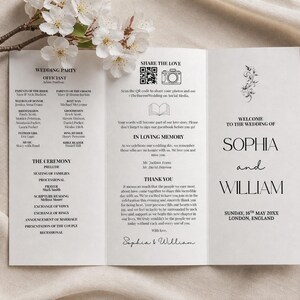 May include: A white wedding program with black text, featuring the names "Sophia and William." The program includes details of the ceremony, wedding party, and a thank you message. A sprig of white flowers rests on the top.