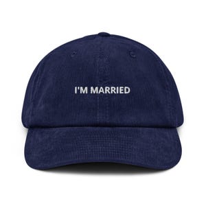 May include: A navy blue corduroy baseball cap with the embroidered text "I'M MARRIED" in white. The cap features a curved peak and a structured crown. A casual accessory.