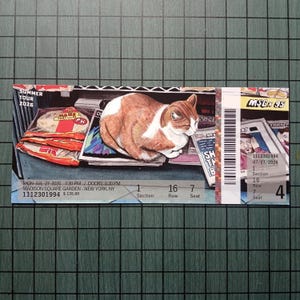May include: A rectangular concert ticket for Summer Tour 2026 at Madison Square Garden, New York, NY. The ticket features an illustration of a brown and white cat resting on newspapers, a package of Maze Tortilla, a barcode, and seat details.