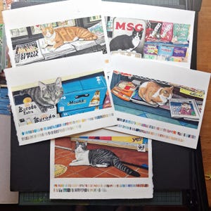 May include: A collection of five rectangular art prints featuring detailed illustrations of cats in various store settings, including shelves with snacks, newspapers, and beverages, with colorful paint swatches printed along the bottom edge of each.