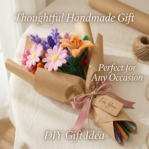 K&ouml;nnte beinhalten: Ein handgemachter Blumenstrau&szlig; aus bunten Pfeifenblumen, verpackt in braunem Papier, mit einer rosa Schleife und einem "For You"-Anh&auml;nger gebunden. Der Strau&szlig; enth&auml;lt rosa G&auml;nsebl&uuml;mchen, orange Lilien und lila Lavendel. Text lautet "Thoughtful Handmade Gift" und "DIY Gift Idea".
