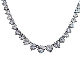 May include: A silver necklace with a row of large, clear, round gemstones.